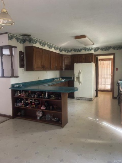 Kitchen with fridge, pendant lighting, and dark brown cabinetry