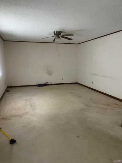 Empty room featuring ceiling fan and a textured ceiling