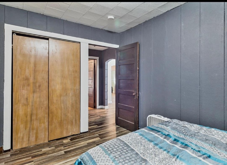 Bedroom with a closet and dark hardwood / wood-style floors