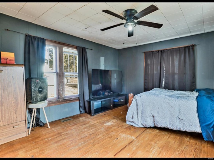 Bedroom with hardwood / wood-style flooring and ceiling fan