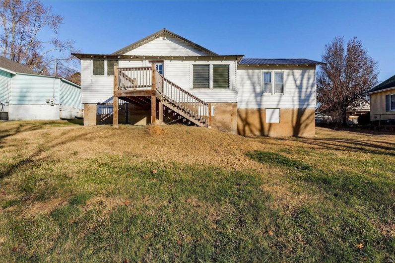 Rear view of property with a wooden deck and a lawn