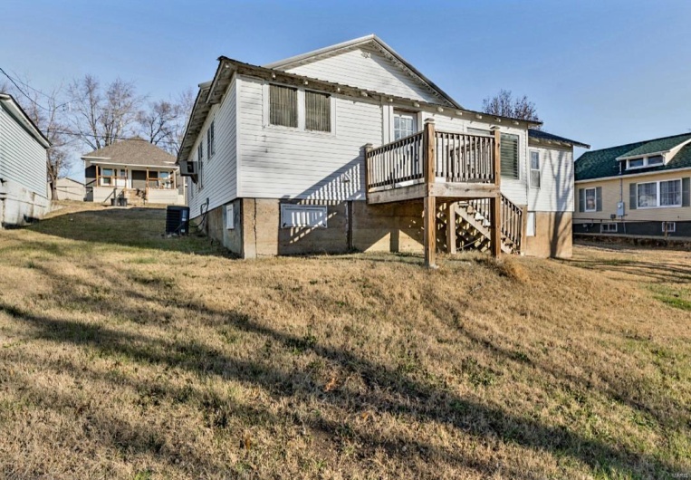 Rear view of property with a deck, a yard, and central air condition unit