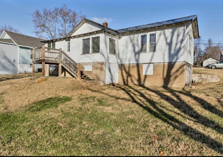 Rear view of property with a yard and a deck
