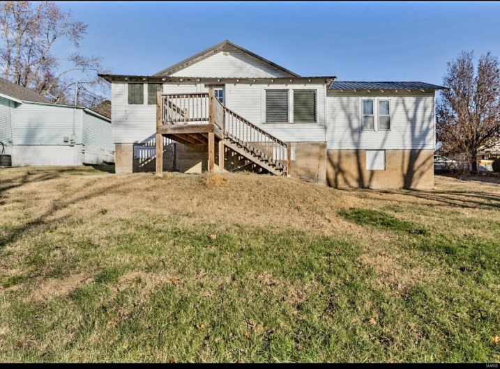 Rear view of house with a yard