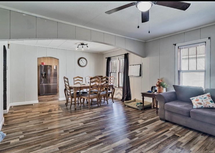 Living room featuring ceiling fan, dark hardwood / wood-style flooring, and crown molding