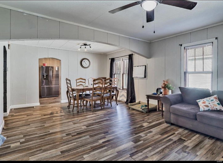 Living room with ceiling fan, crown molding, and dark hardwood / wood-style floors