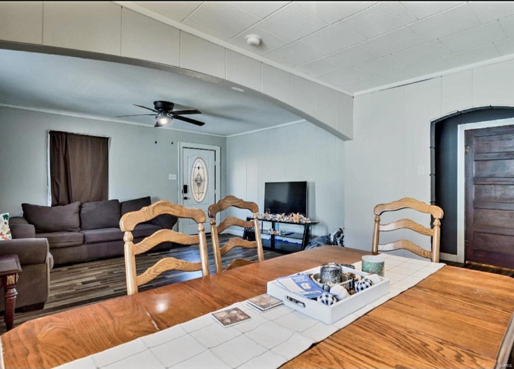 Living room featuring ceiling fan and ornamental molding