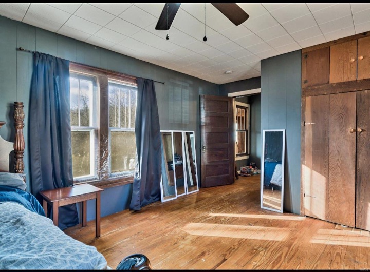 Unfurnished bedroom with ceiling fan and wood-type flooring