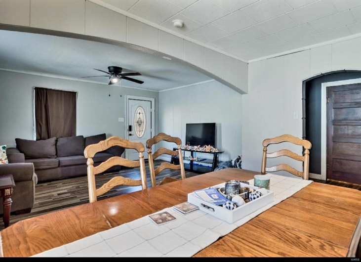 Living room with ceiling fan and ornamental molding