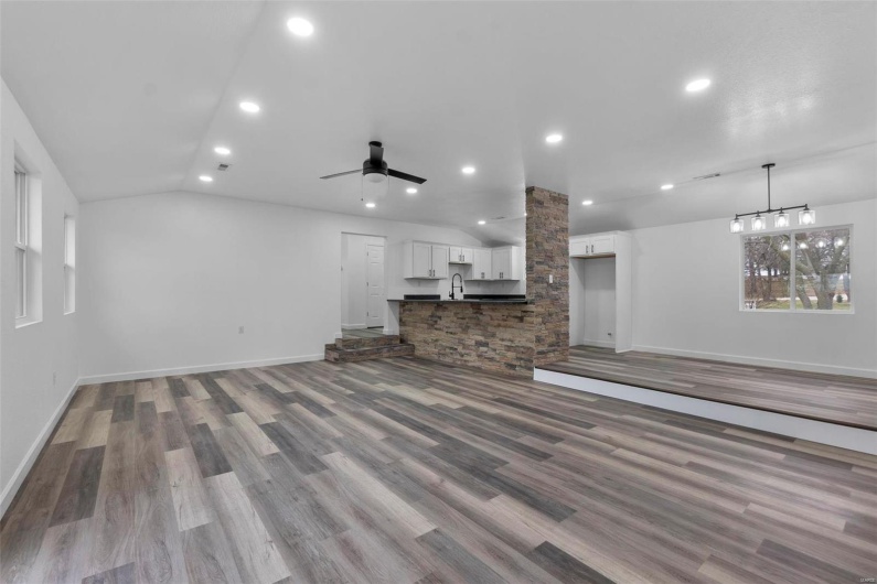 Unfurnished living room with ceiling fan, recessed lighting, wood finished floors, a sink, and vaulted ceiling