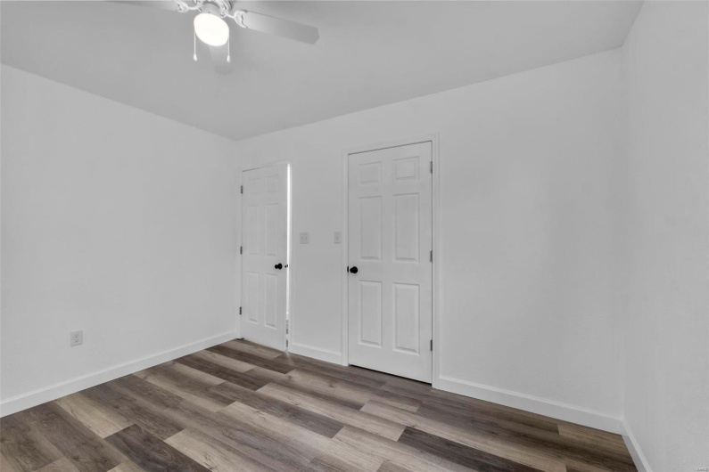 Unfurnished room featuring a ceiling fan, baseboards, and wood finished floors