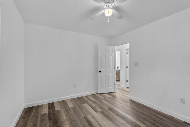 Unfurnished room with a ceiling fan, baseboards, and wood finished floors