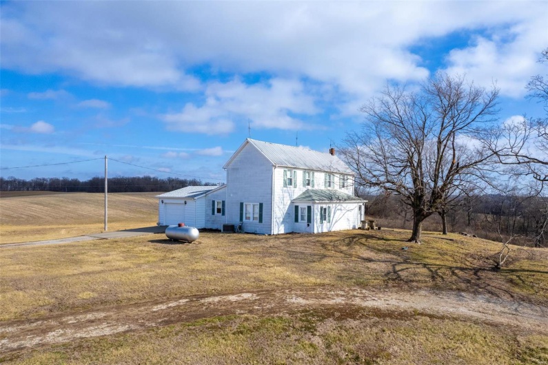 View of side of property with a garage and a lawn