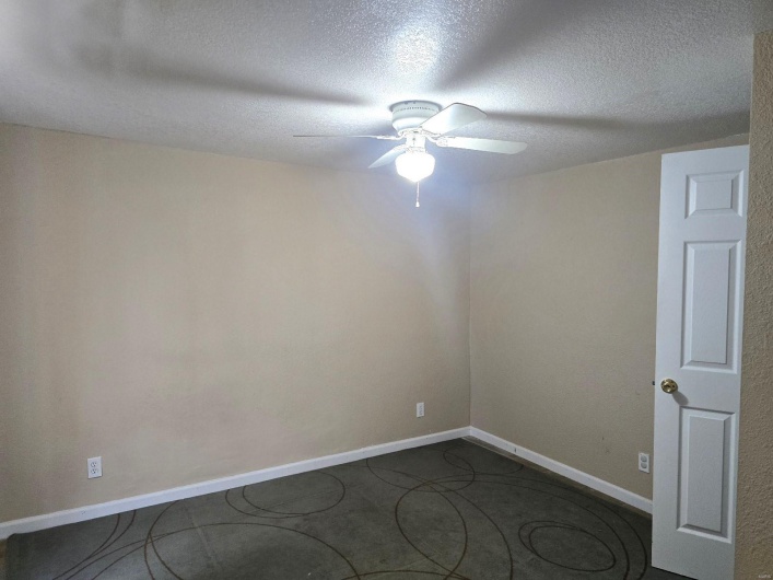 Spare room with a textured ceiling and ceiling fan