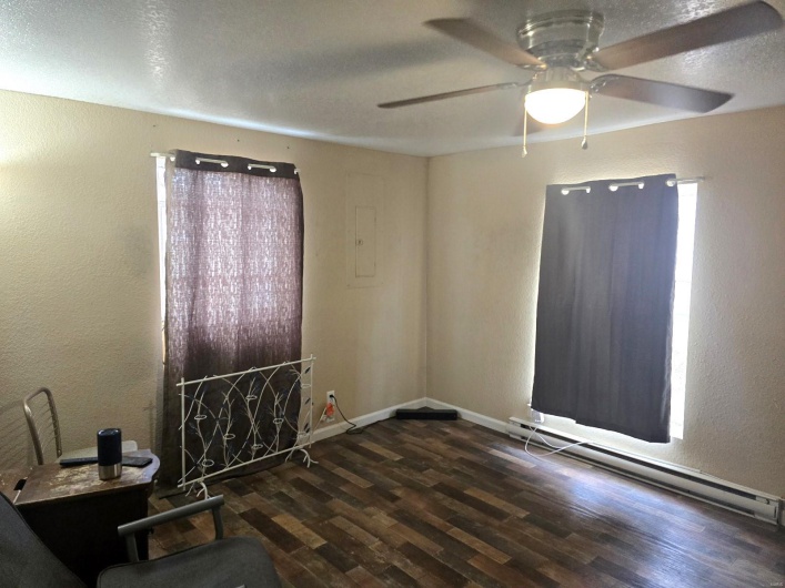 Spare room with ceiling fan, dark hardwood / wood-style flooring, a textured ceiling, and a baseboard heating unit