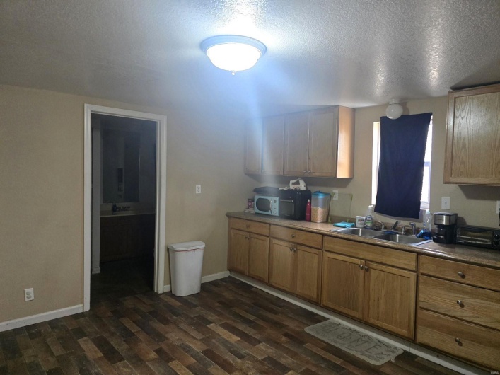 Kitchen featuring dark wood-type flooring, sink, and a textured ceiling