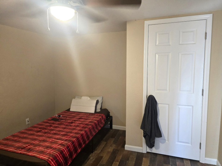 Bedroom with dark hardwood / wood-style floors and ceiling fan