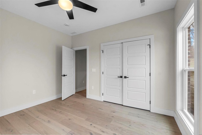 Unfurnished bedroom with ceiling fan, a closet, and light wood-type flooring