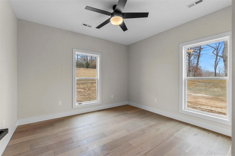 Unfurnished room with ceiling fan and light wood-type flooring