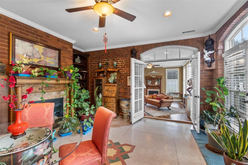 Dining area featuring ornamental molding, a premium fireplace, and brick wall