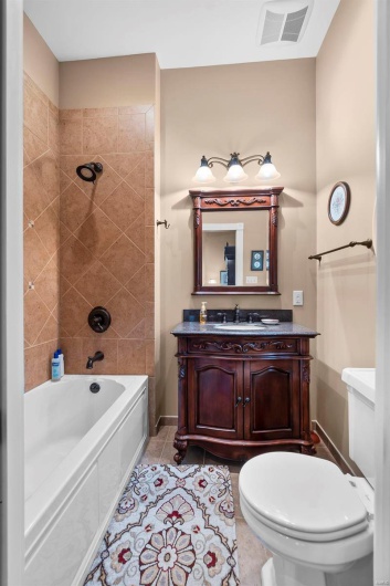 Full bathroom featuring tile patterned floors, toilet, tiled shower / bath combo, and vanity