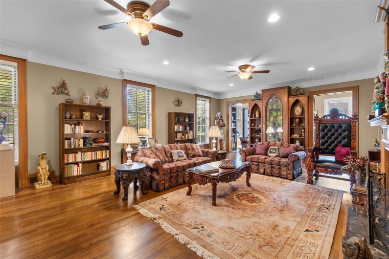 Living room with ornamental molding, a wealth of natural light, and hardwood / wood-style floors
