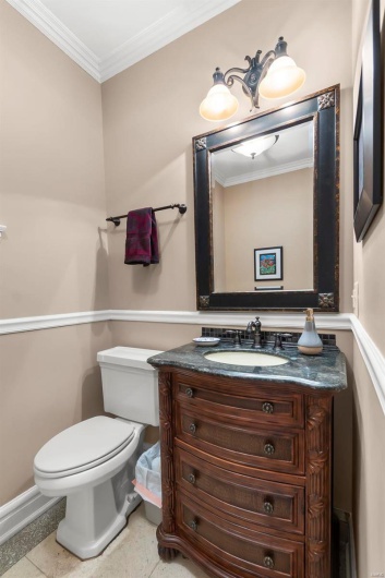 Bathroom featuring vanity, ornamental molding, and toilet