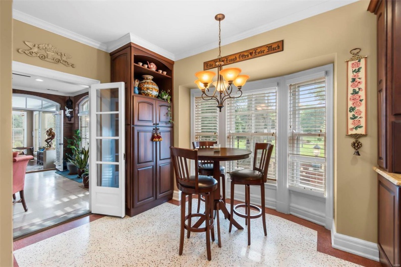 Dining area with crown molding, a healthy amount of sunlight, and an inviting chandelier