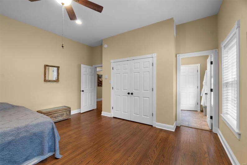 Bedroom with ceiling fan, dark hardwood / wood-style flooring, and a closet