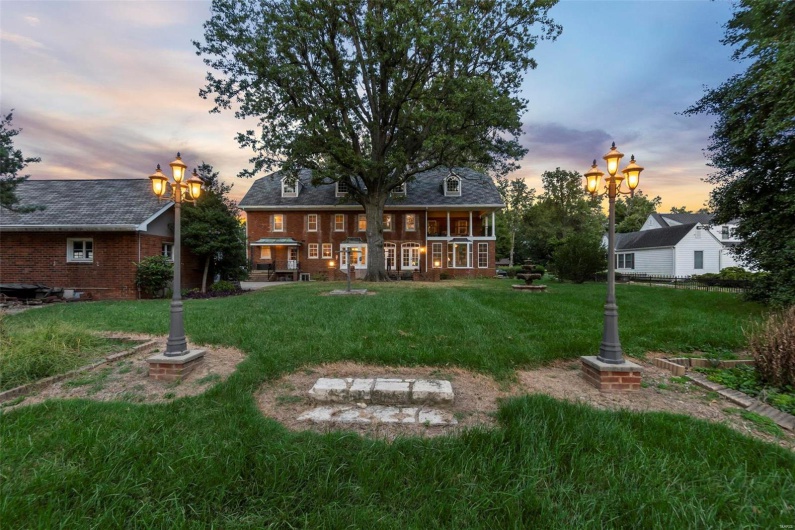 Back house at dusk featuring a yard