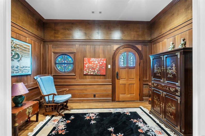 Foyer featuring wooden walls and light wood-type flooring