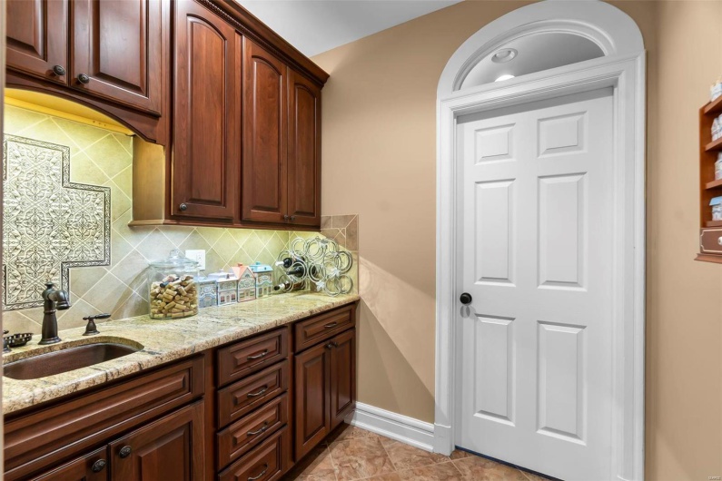 Kitchen with tasteful backsplash, sink, and light stone counters