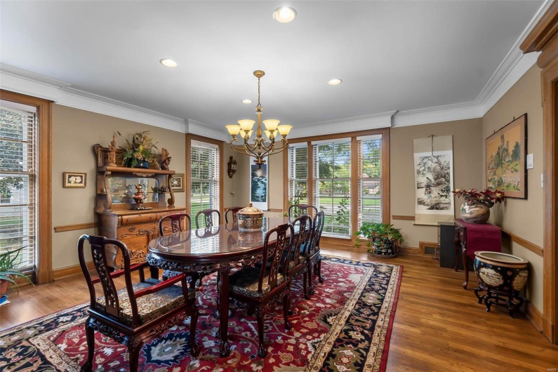 Dining space with an inviting chandelier, hardwood / wood-style floors, and ornamental molding