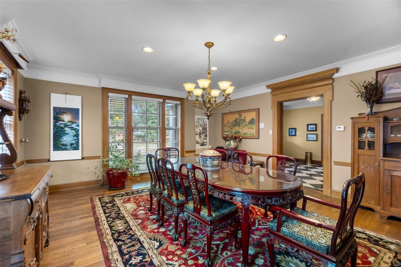 Dining space with crown molding, a chandelier, and light hardwood / wood-style flooring