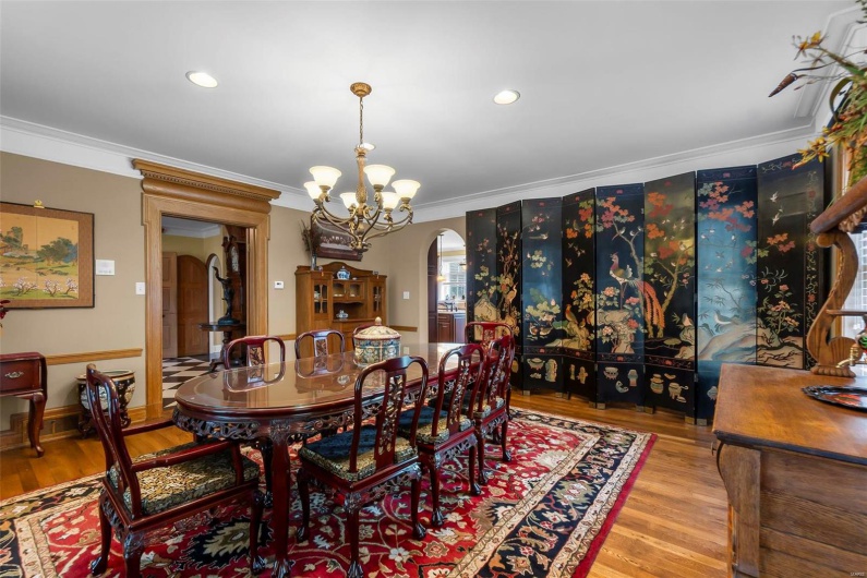 Dining room featuring ornamental molding, wood-type flooring, and a notable chandelier