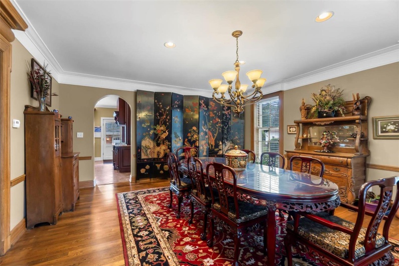 Dining room featuring crown molding, hardwood / wood-style floors, and an inviting chandelier