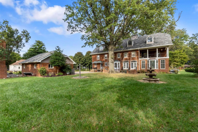 Back of property with a lawn