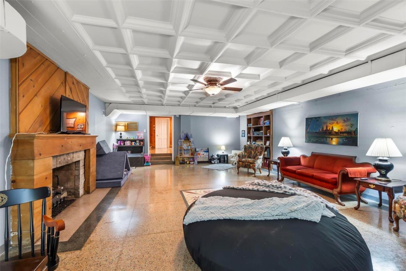 Living room featuring ceiling fan, coffered ceiling, and beam ceiling
