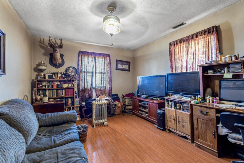 Office space featuring ceiling fan, light hardwood / wood-style floors, and a textured ceiling
