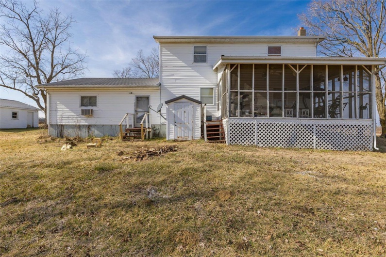 Rear view of property featuring a sunroom and a yard