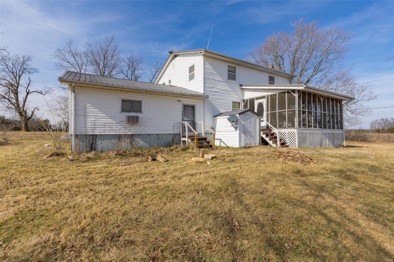 Back of house featuring a sunroom and a lawn