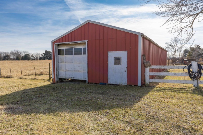 View of outbuilding featuring a yard, a rural view, and a garage