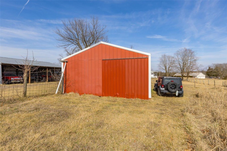 View of outdoor structure featuring a lawn