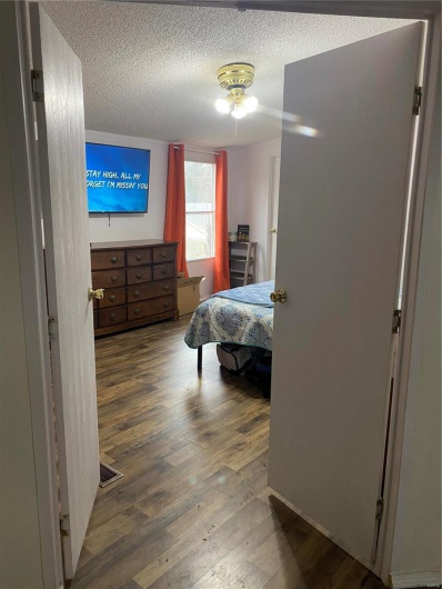 Bedroom with hardwood / wood-style flooring and a textured ceiling