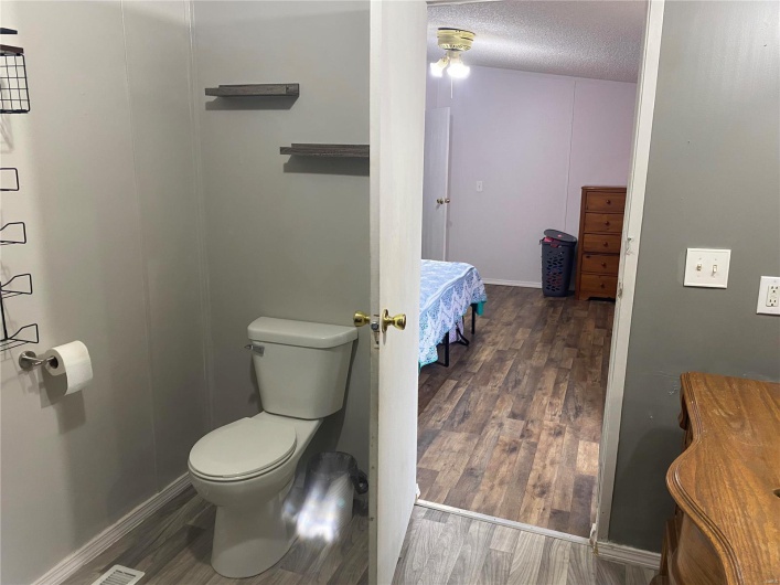 Bathroom featuring toilet, hardwood / wood-style floors, and a textured ceiling