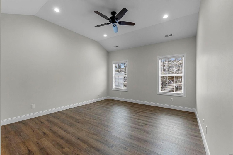 Unfurnished room with ceiling fan, vaulted ceiling, and dark hardwood / wood-style flooring