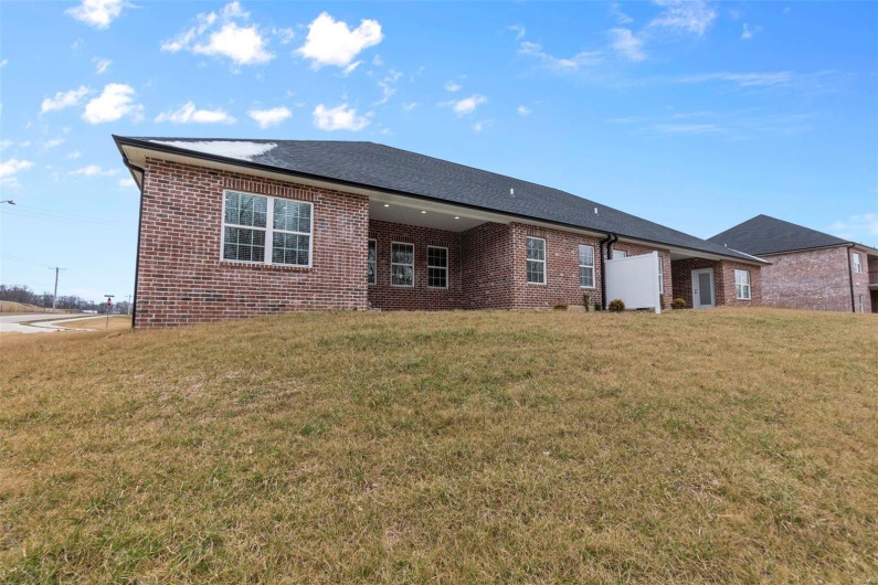 Rear view of house featuring a lawn