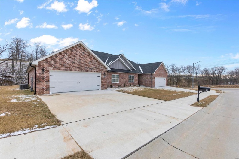 View of front of house featuring a garage, central AC, and a front lawn