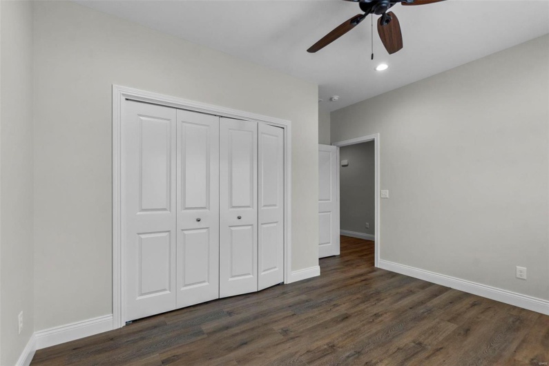 Unfurnished bedroom with dark wood-type flooring, ceiling fan, and a closet