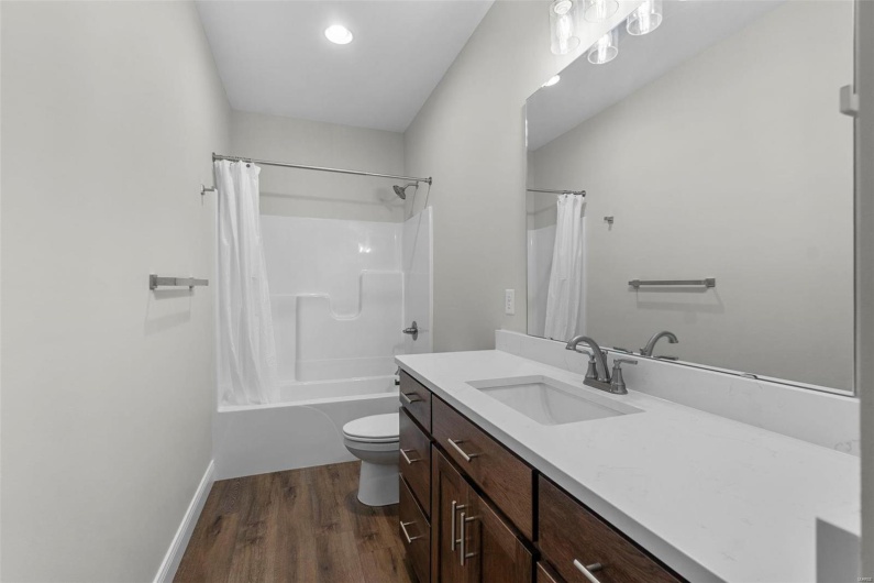 Full bathroom featuring shower / tub combo, toilet, hardwood / wood-style flooring, and vanity